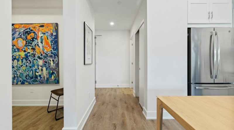 A grocery bag left outside an apartment door in a hallway.