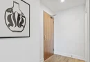 An apartment hallway with a doorway and floor mat.