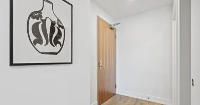 An apartment hallway with a doorway and floor mat.