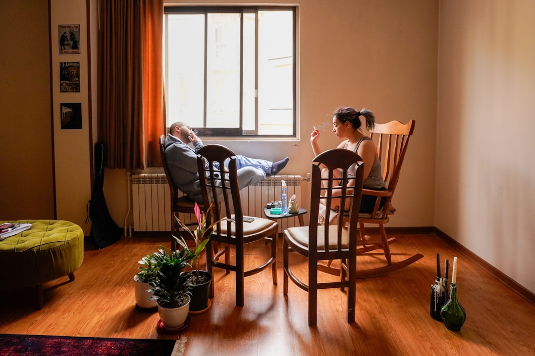 Two adult daughters spending time with their elderly father at home.