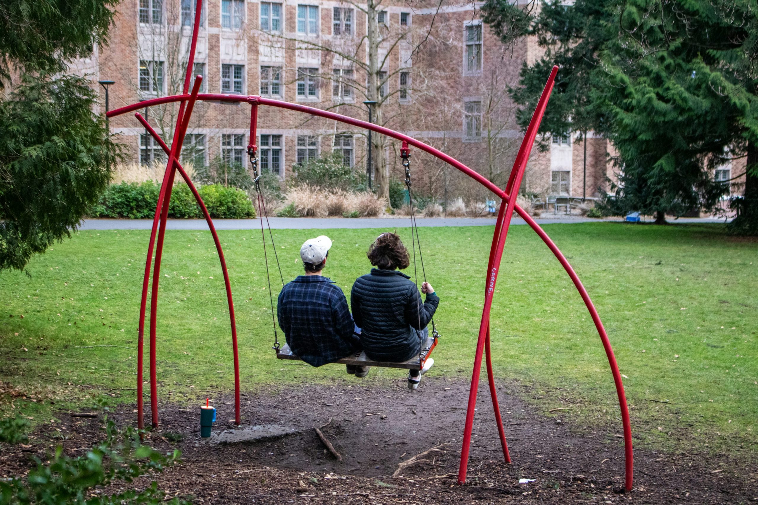 Two adult siblings talking together outdoors.