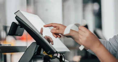 A cashier working with money and receipts at a retail counter.