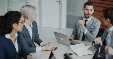 Business professionals reviewing presentation materials during a client meeting.