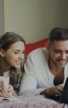A married couple discussing finances together at home with a laptop.