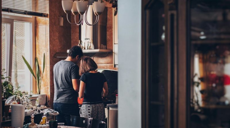 A couple together in a home kitchen.