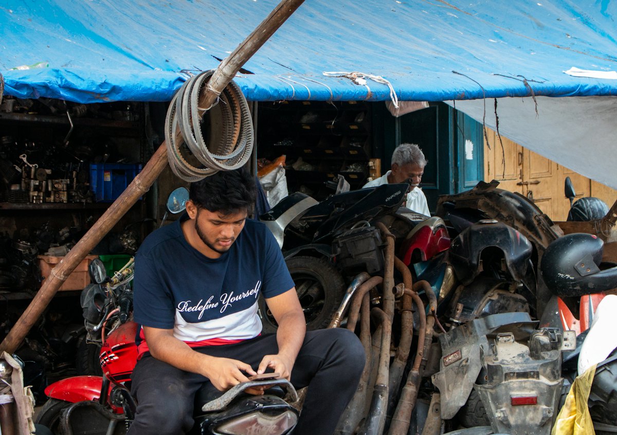 A repair workshop with technicians surrounded by tools and mechanical parts.