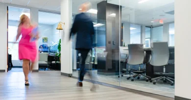 An employee walking through an office corridor in the afternoon.