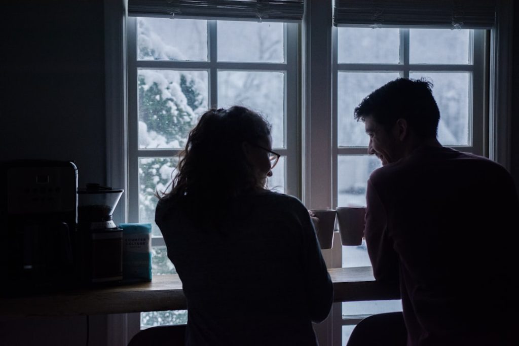 Two people sitting together in the evening, representing a private conversation.