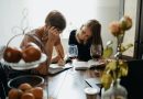 Two adults talking together at a table, representing a family caregiving conversation.