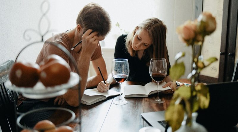Two adults talking together at a table, representing a family caregiving conversation.