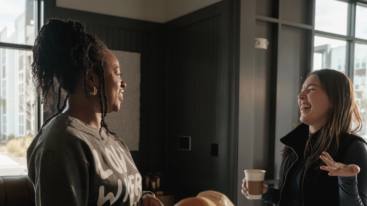 Two adult friends talking together over coffee at home.