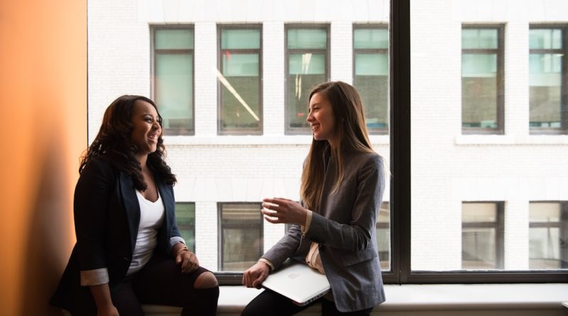 Two female friends in conversation, representing a friendship strained after a promotion.