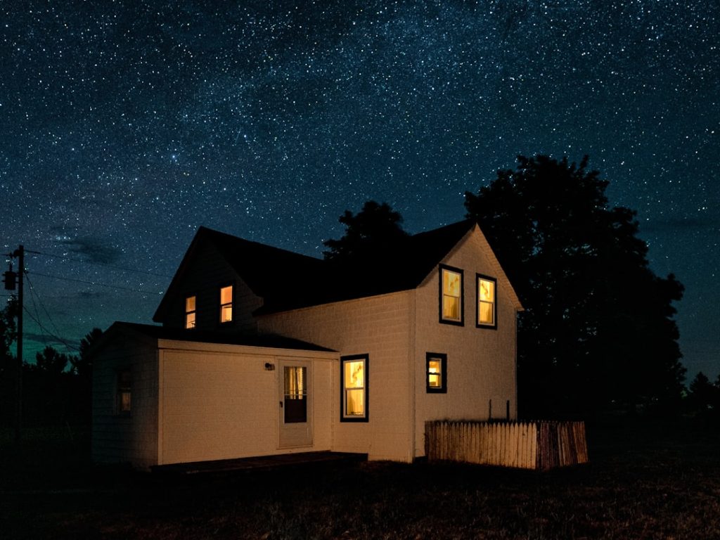 A house and porch illuminated at night.
