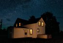 A house and porch illuminated at night.
