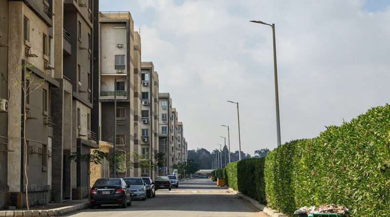 A residential street, representing a dispute between neighbors over trash bins and curb space.