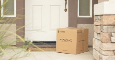 A cardboard package left beside a front door.