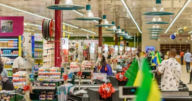 Shoppers moving through a brightly lit supermarket.