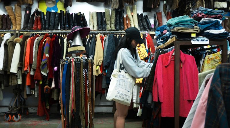 A shopper browsing vintage clothing in a thrift store.