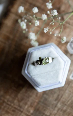A vintage ring resting in a small jewelry container.